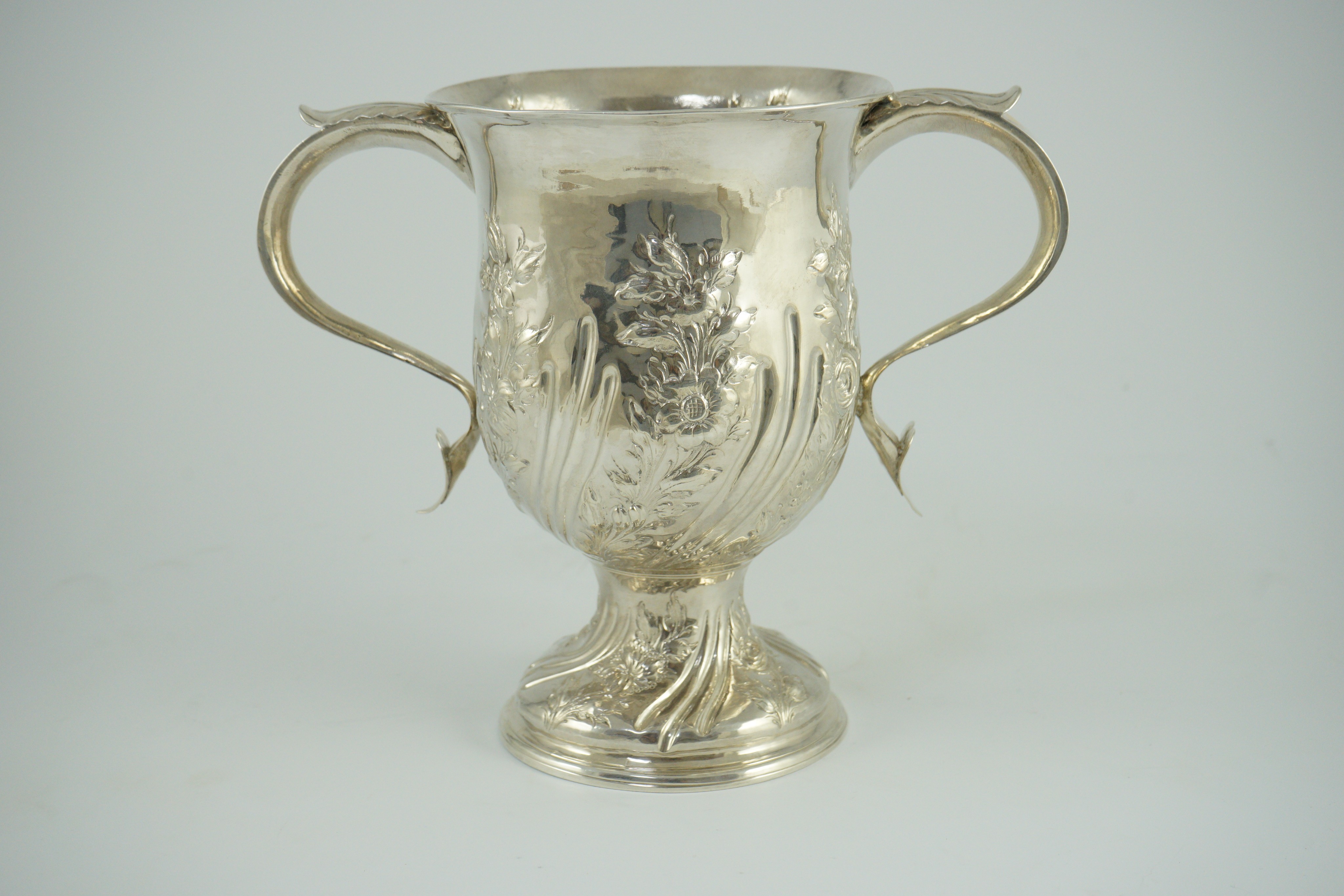 A George III silver baluster two handled pedestal cup, with later embossed decoration, by John Scofield